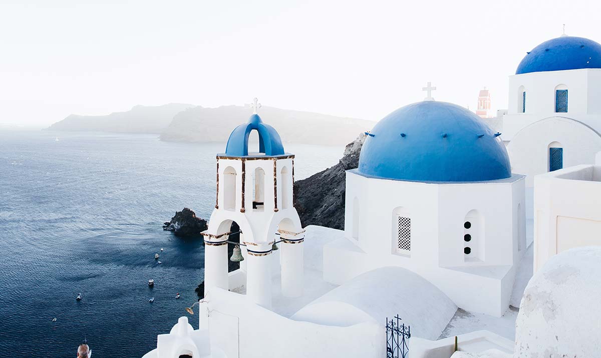 Casas gregas brancas típicas com cúpulas azuis em Santorini