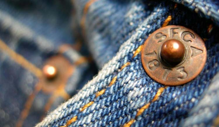 Por que as calças jeans têm rebites de metal nos bolsos?